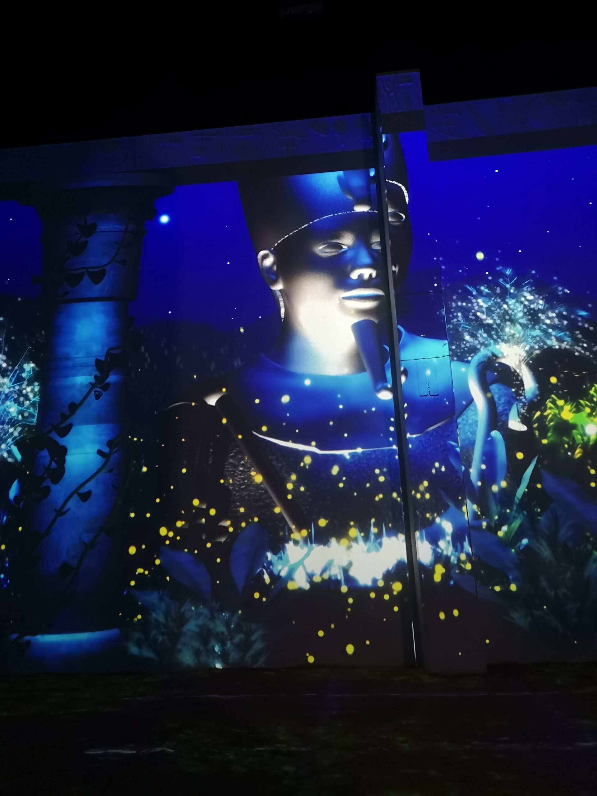 Image of the immersive spectacle of Immersive Tut. In the wall, the statue of a king appears.